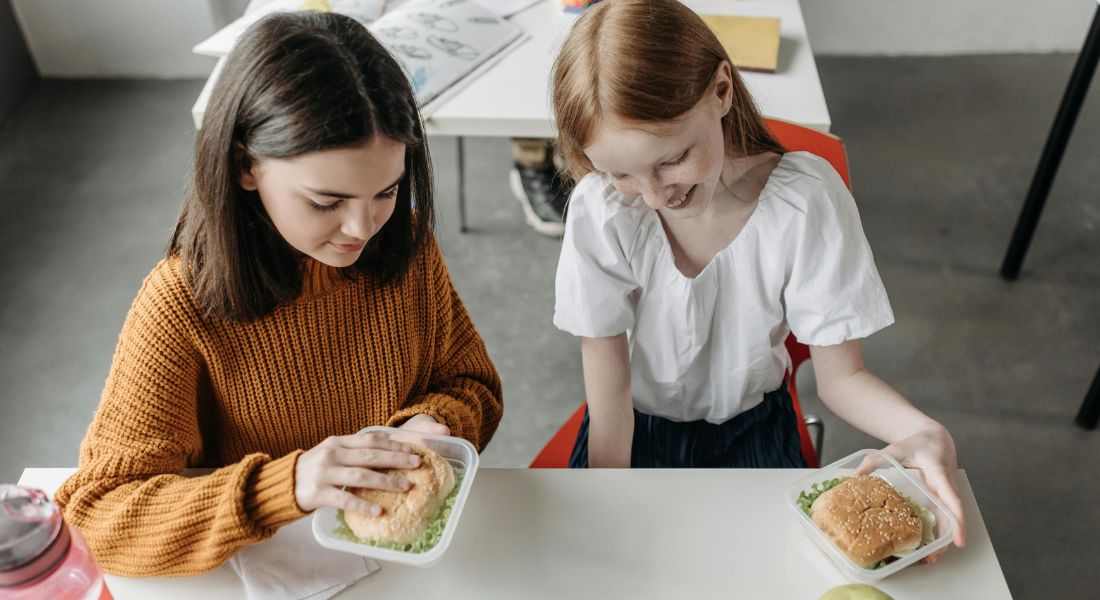 To skolepiger der spiser frokost